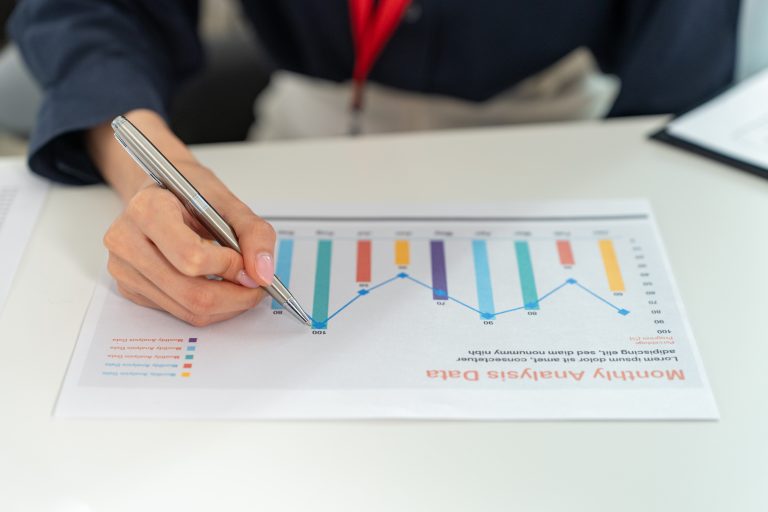 Close,Up,Hand,Holding,Pen,Pointing,At,Graph,Using,Calculator